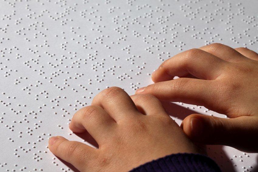 Girl's hands reading braille