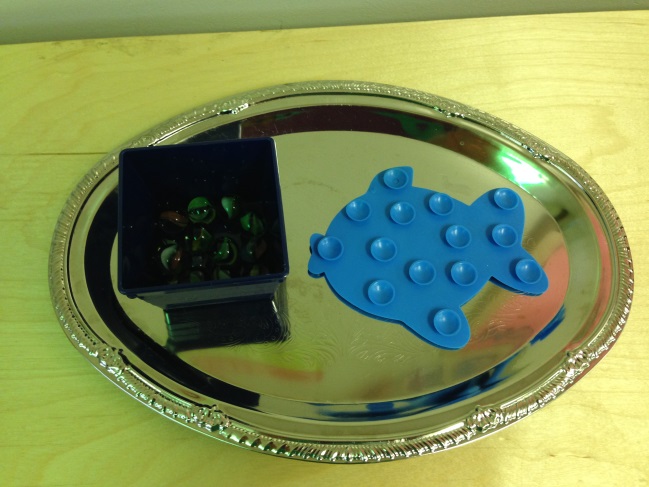 Activity to place marbles on circles on fish