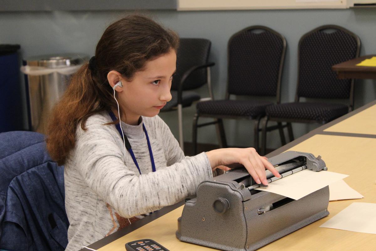 A girl using a Perkins braillewriter