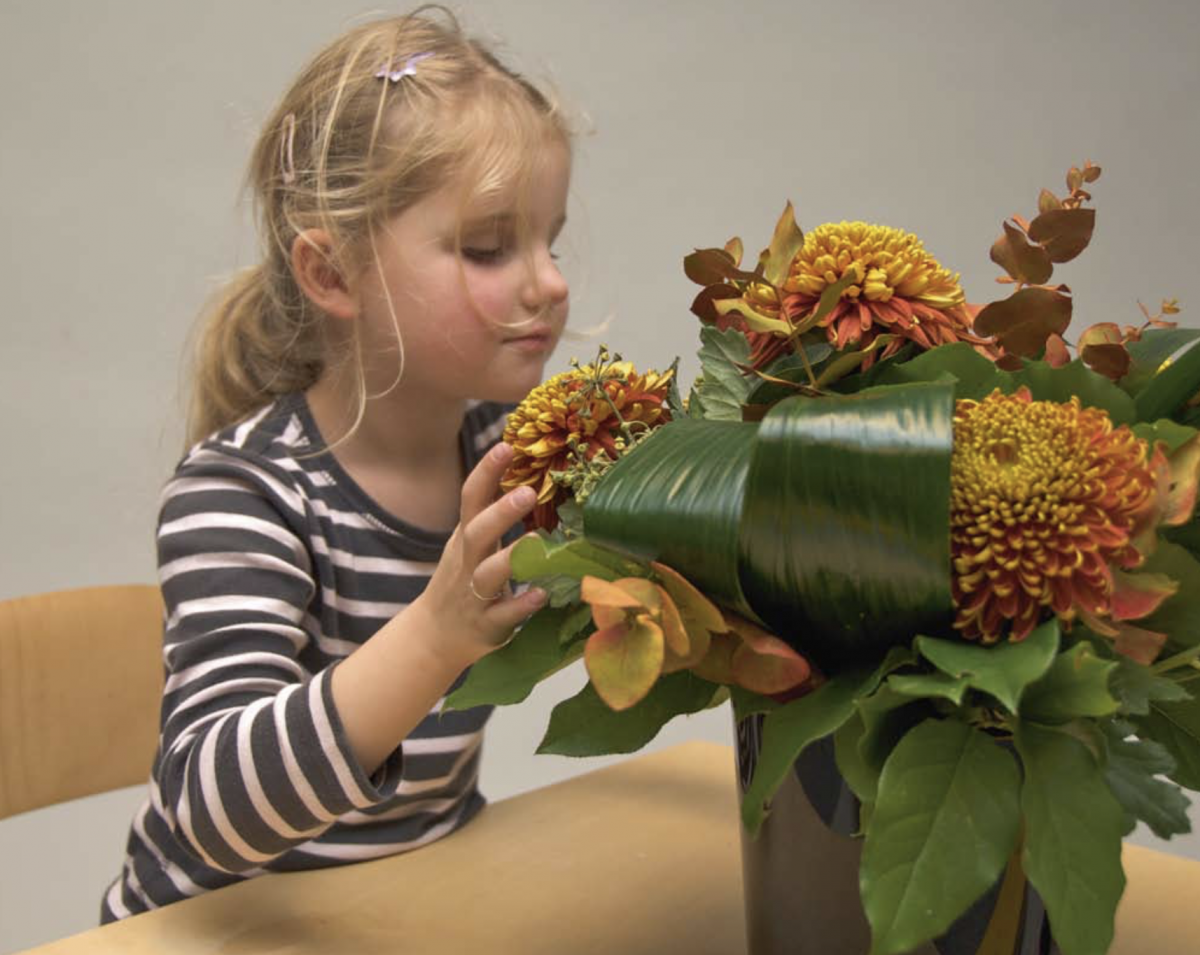 A young girl explores flowers