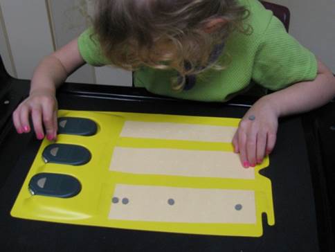 A student using an APH soundboard and marked high dots
