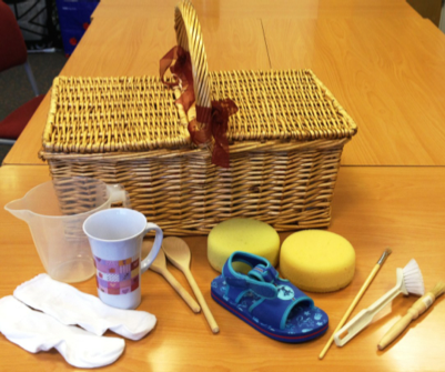 basket with sponges, spoons, mug, socks, brushes, sandal
