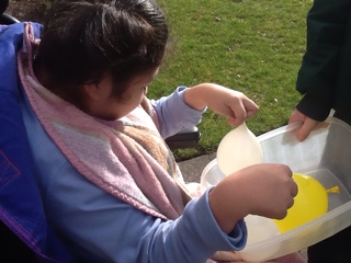 student holding white water balloon
