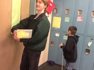 student carrying water balloons in Tupperware container
