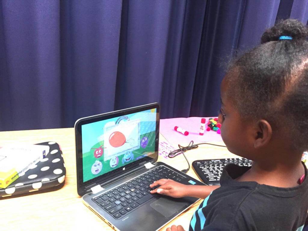 A young girl looks at the Ballyland app on a computer