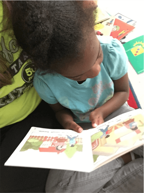 A young girl looking at a picture book