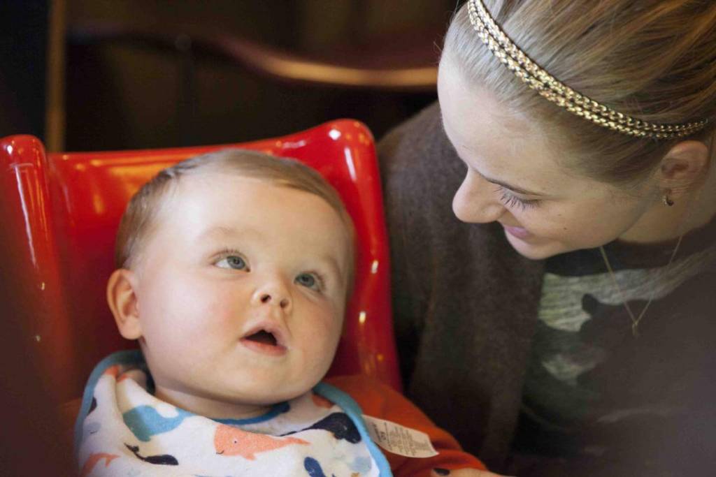 A young baby looks up at his mother