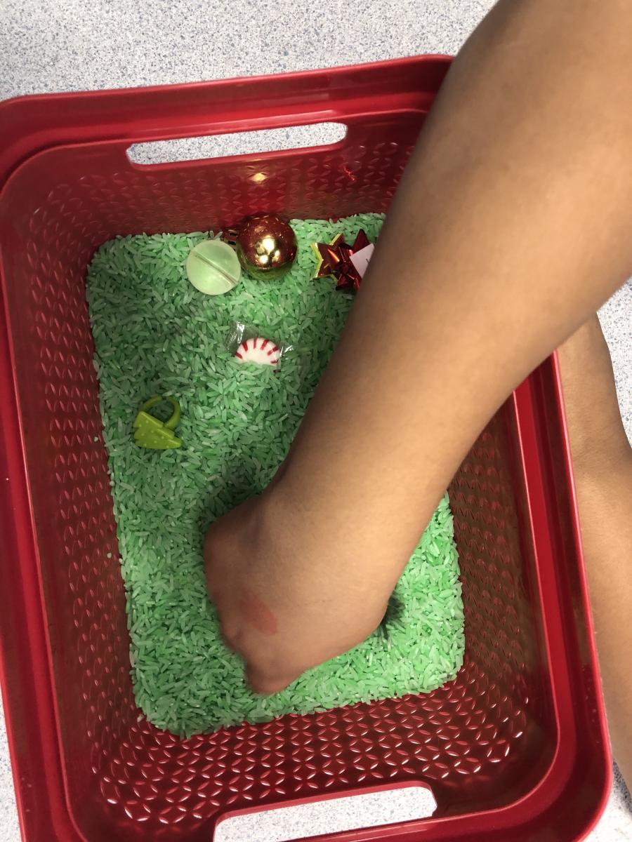 Reaching into the bin of colored rice