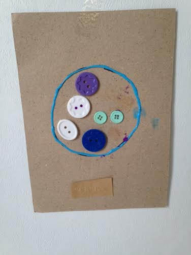 buttons in a puff paint circle on paper 