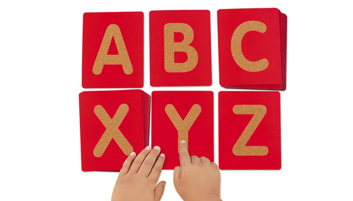 Letter flashcards A B C X Y Z with child hands exploring it