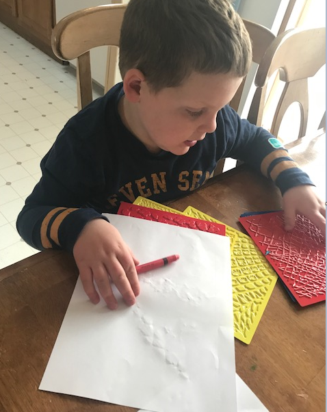 Liam uses plastic sheets with different textures representing different animal skin patterns