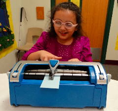 student using Perkins Brailler