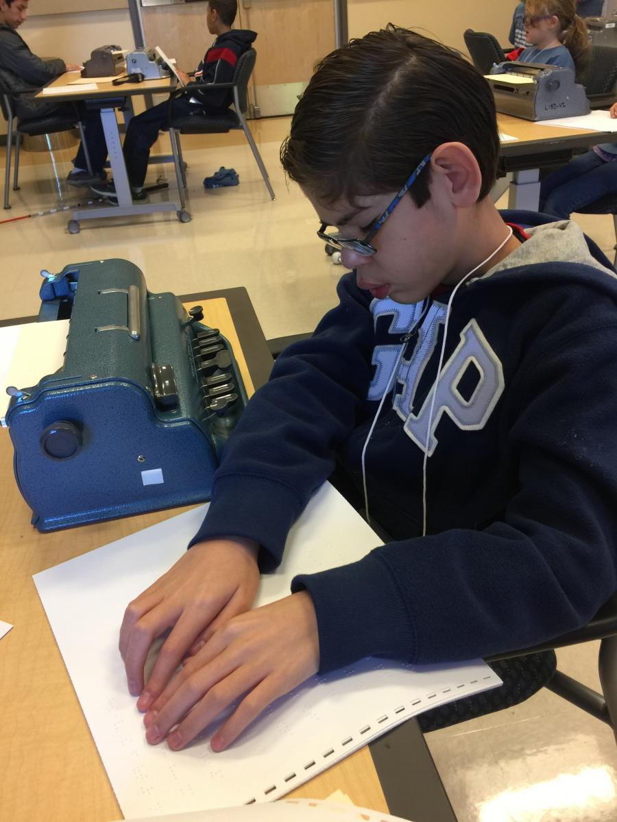 A student reads a braille passage.