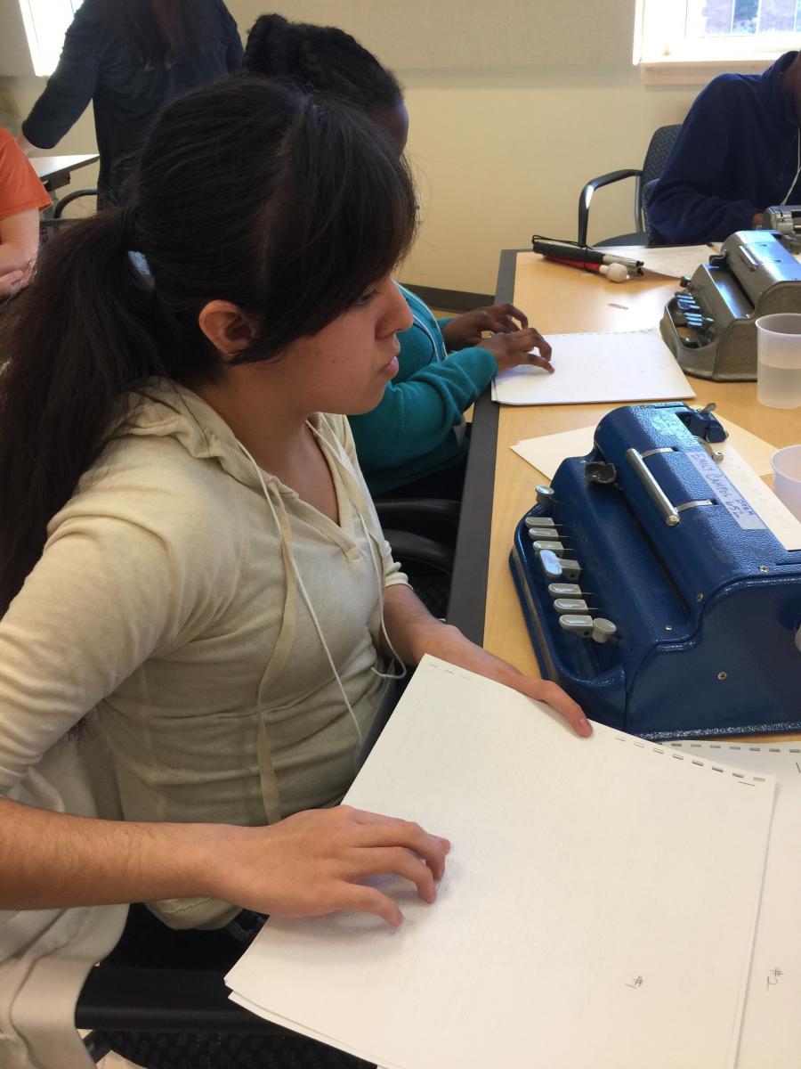 A girl reads a braille text during the Braille Challenge.