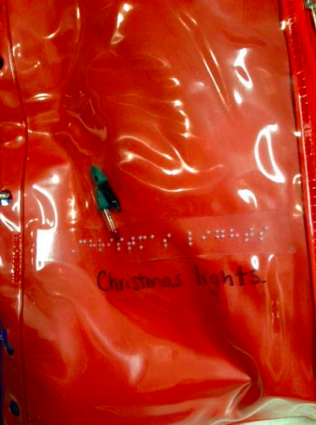 4. Christmas Lights Zipper pouch with braille label "Christmas lights" and Christmas light inside