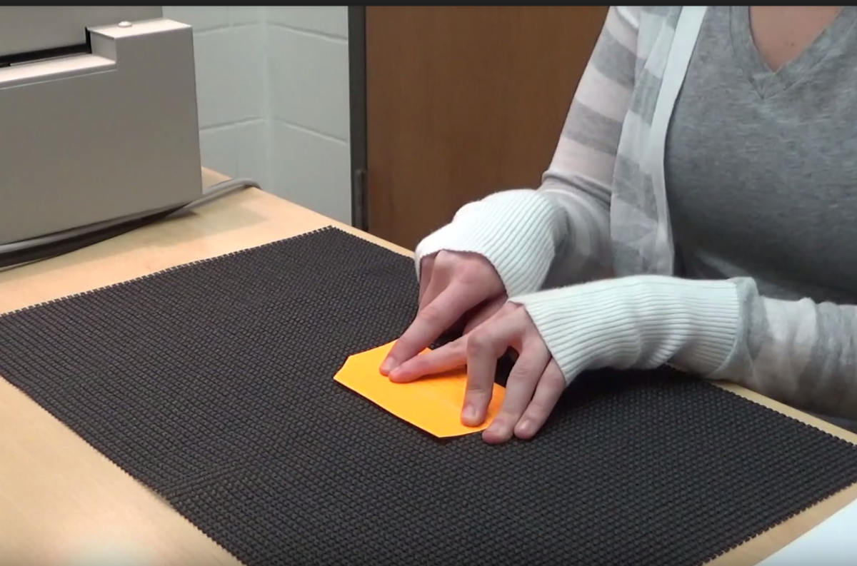 Student reading braille flashcard