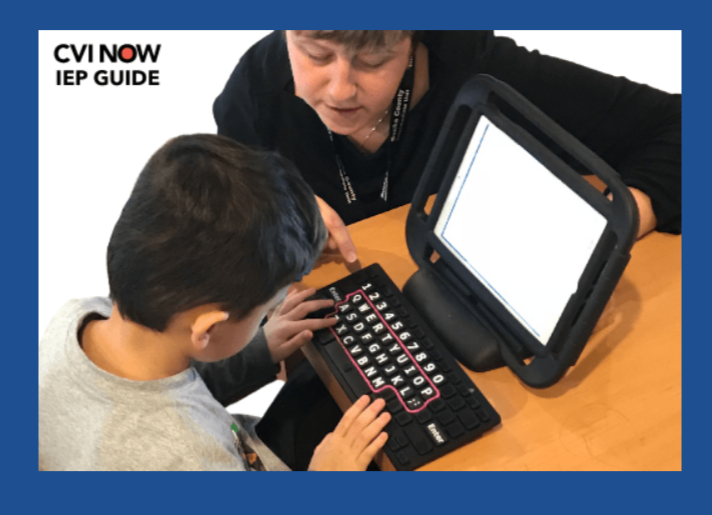 CVI Now  IEP Guide words with a picture of an elementary student typing on a high contrast keyboard with his teacher next to him