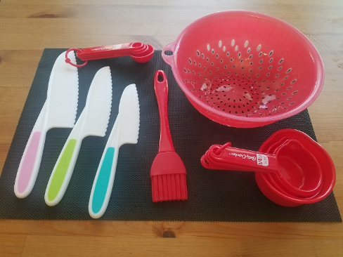 Red utensils and safety knives on black background