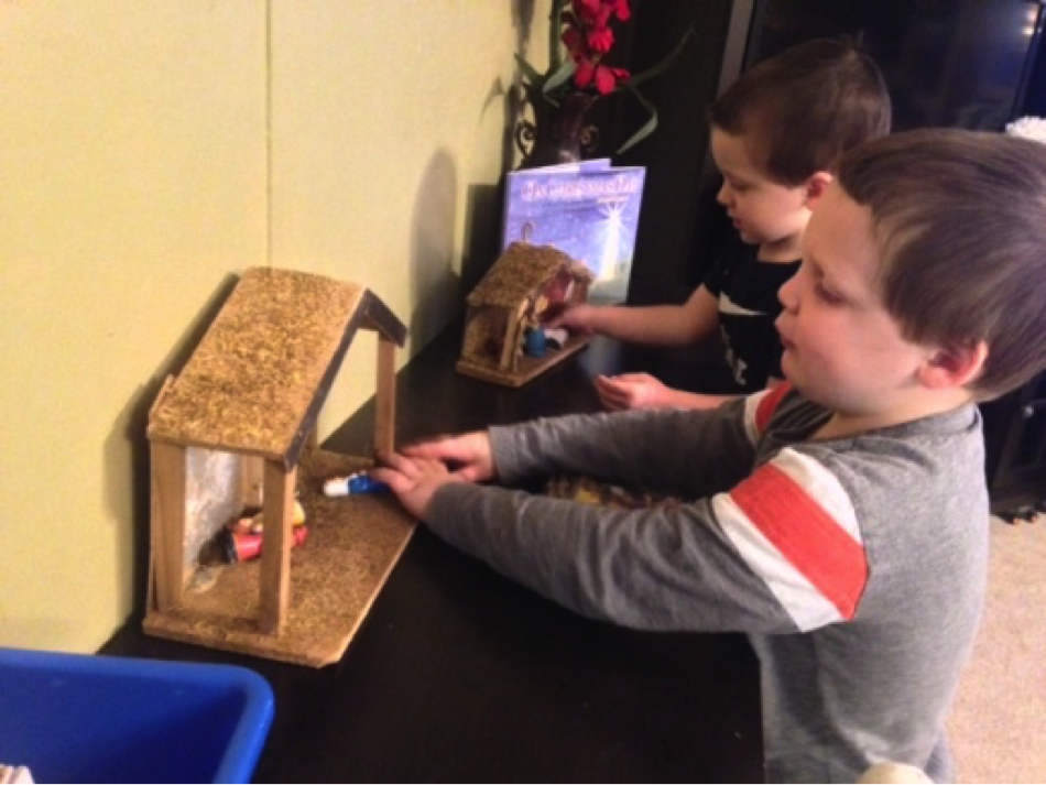 Liam and friend touching the nativity scenes