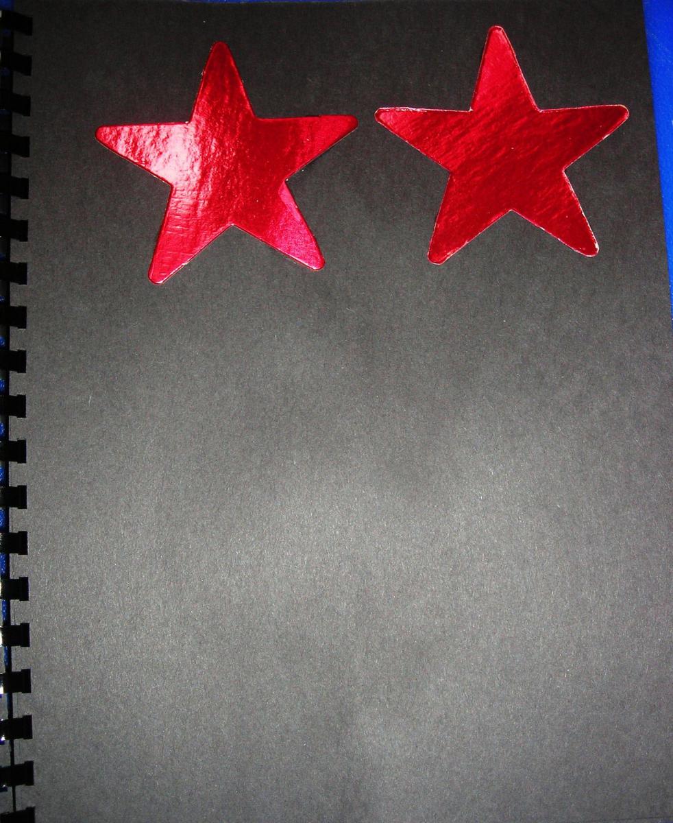 Two red stars on black paper