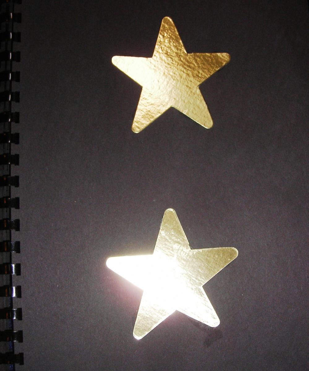 Two gold stars on black paper