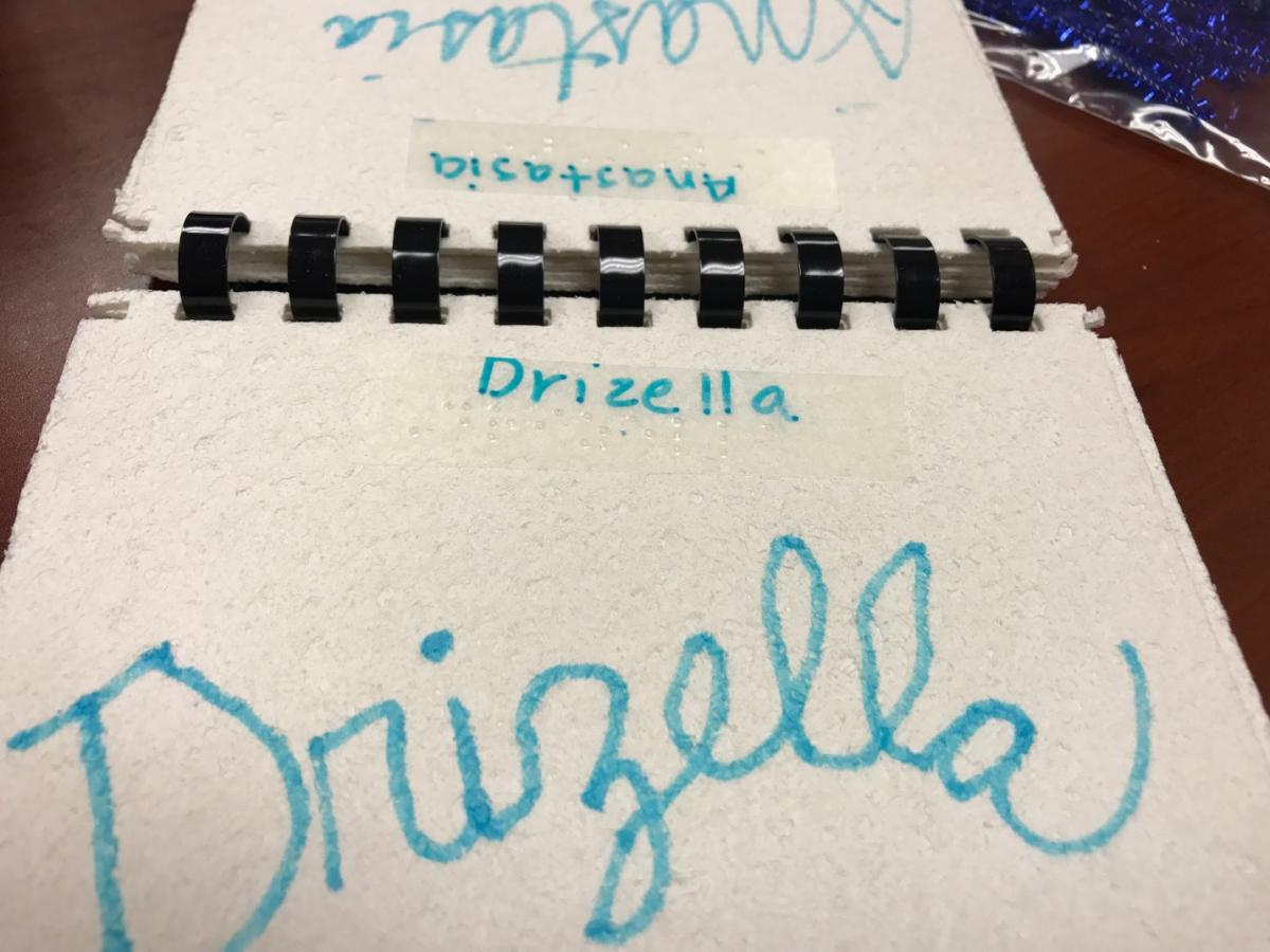 Drizella's signature on a piece of paper labeled with Drizella in braille