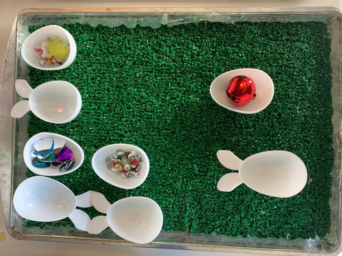 Plastic Easter eggs with beads and small toys inside on an astroturf background 