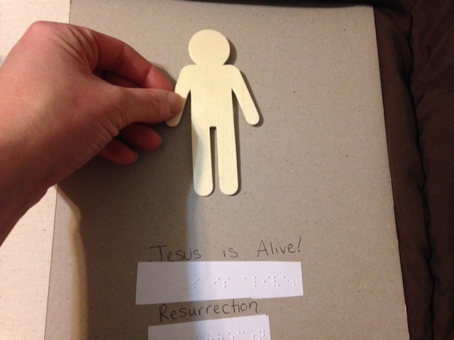 Wooden figure with braille and print text