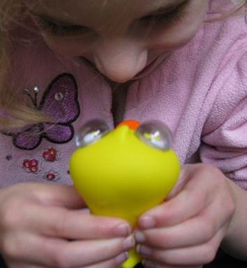 child playing with eye popping duck