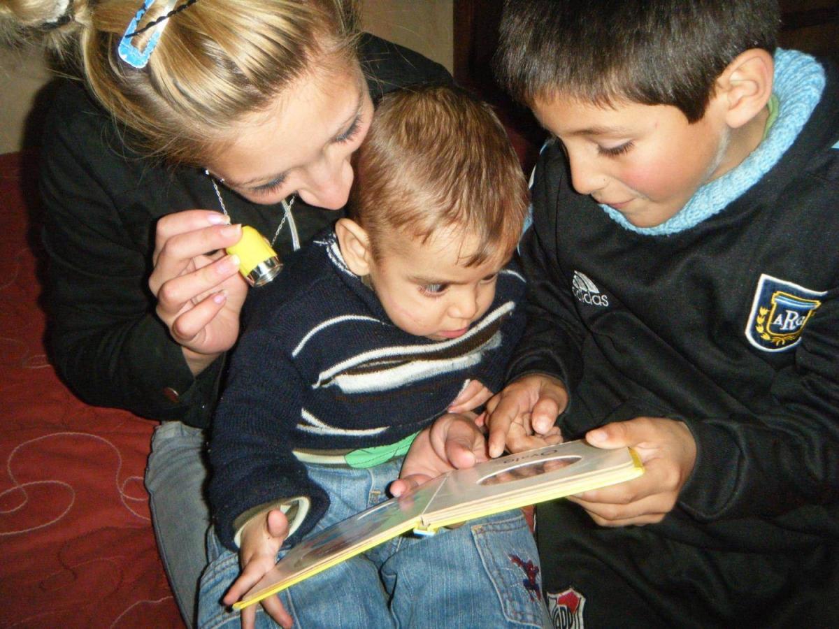 Mother and two sons reading together