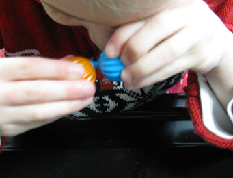 Child putting together two popbeads
