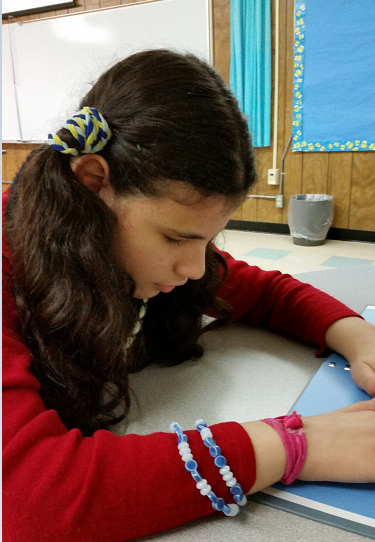 Heba, a young woman with a ponytail, reading