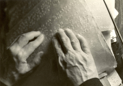 Helen Keller reading braille