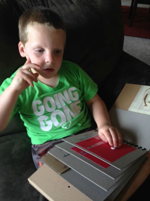 Click to view liam in green shirt using his adapted caterpillar book