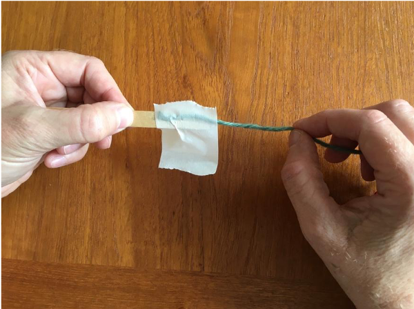 Taping end of yarn to shed stick