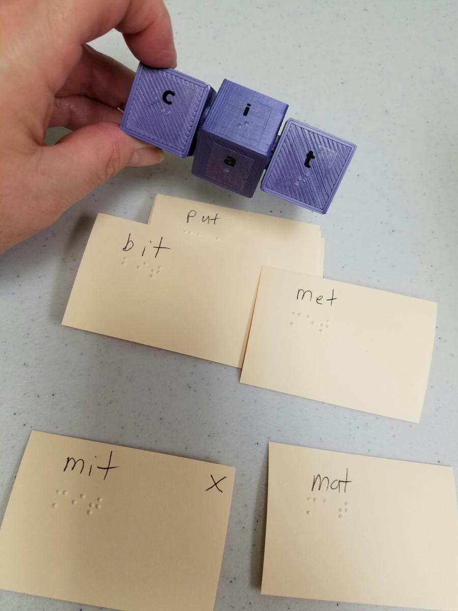 Click to view word cube. Word cube with braille
