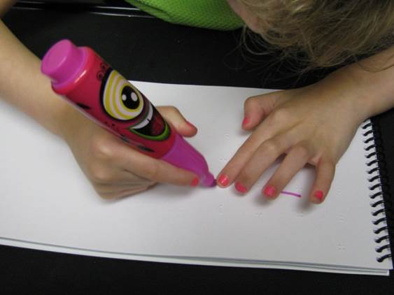 girl with large pen writing on paper