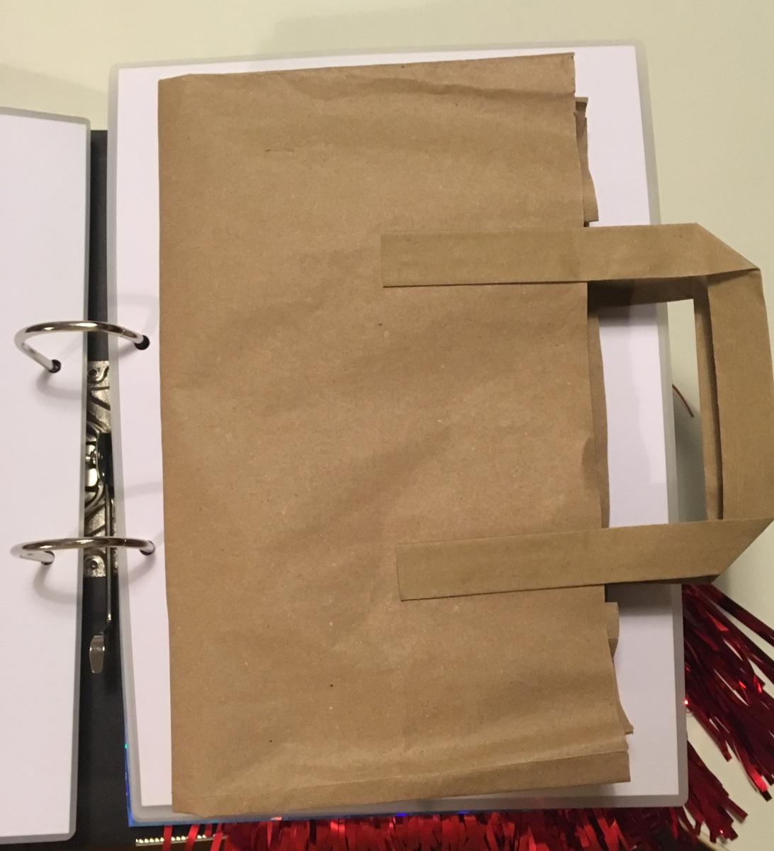 Paper bag attached to page of book