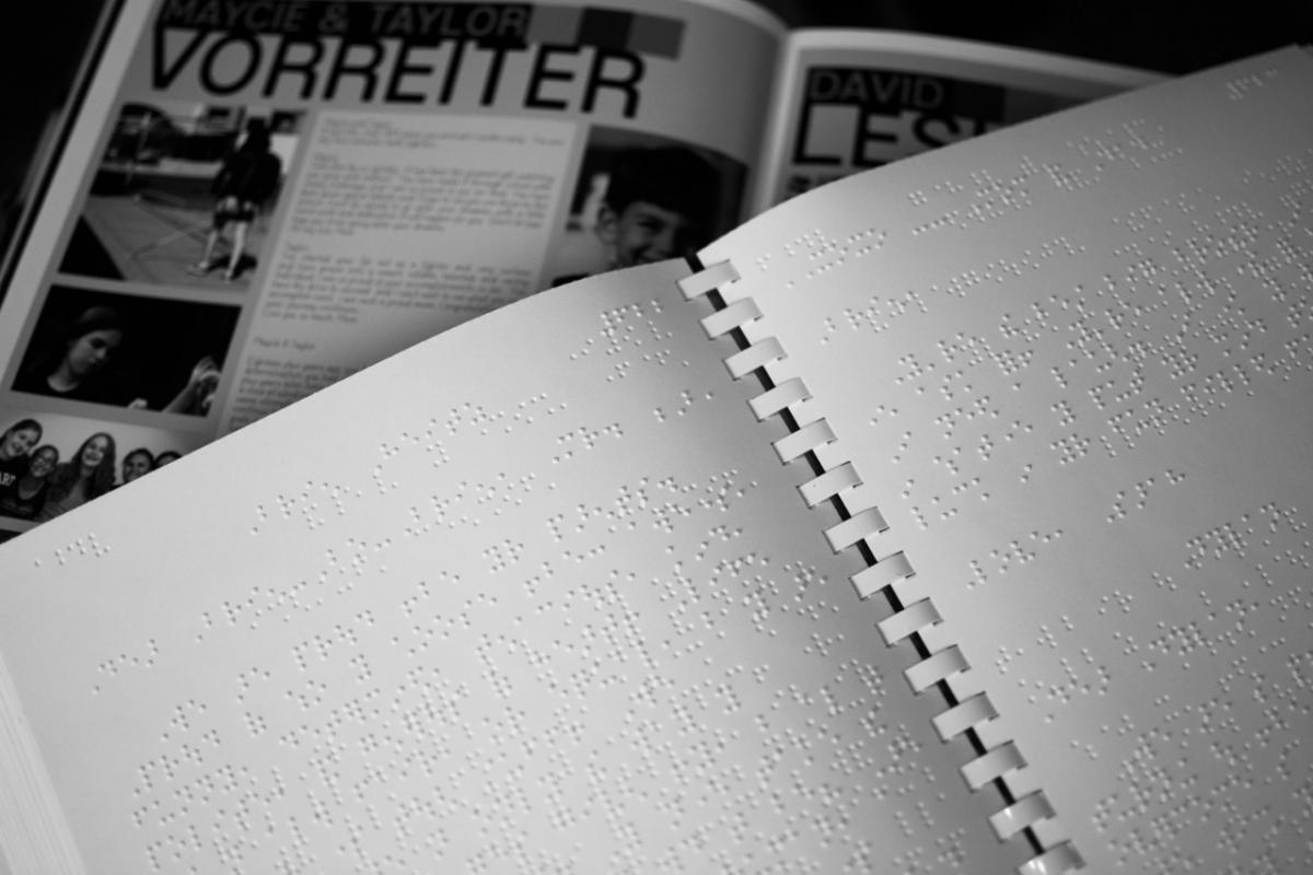 Braille yearbook with print copy in background Braille yearbook with print yearbook in background