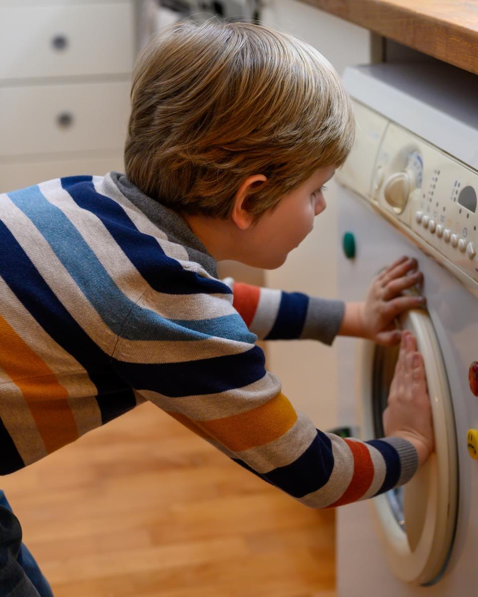 A young boy helps with the laundry.