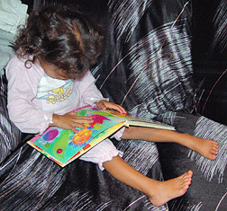 Young girl reads early braille book