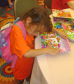 Young girl examines early literacy materials