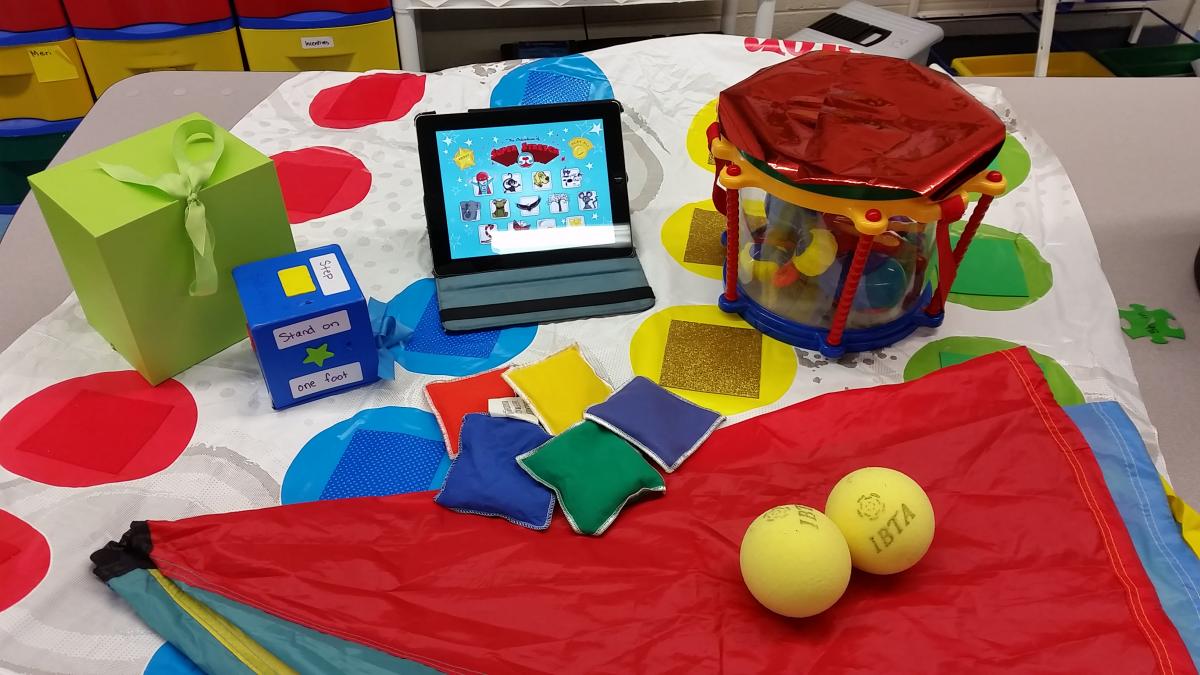 items for indoor and outdoor movement activities including bean bags, a drum, balls, and a Twister board