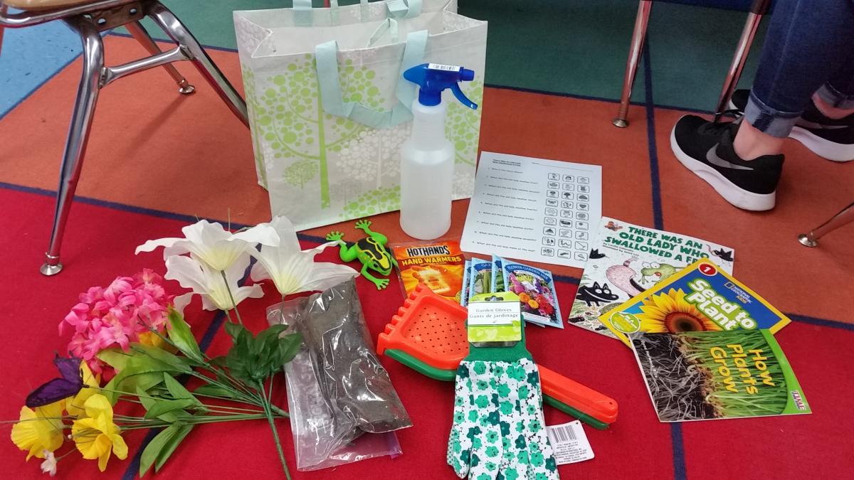 a bag with items such as fake flowers and gardening gloves as well as books about spring