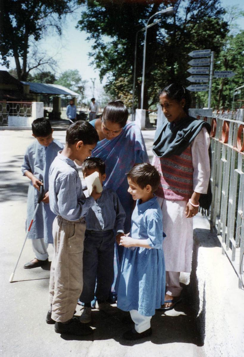 An older student shows younger students the postcards he purchased.