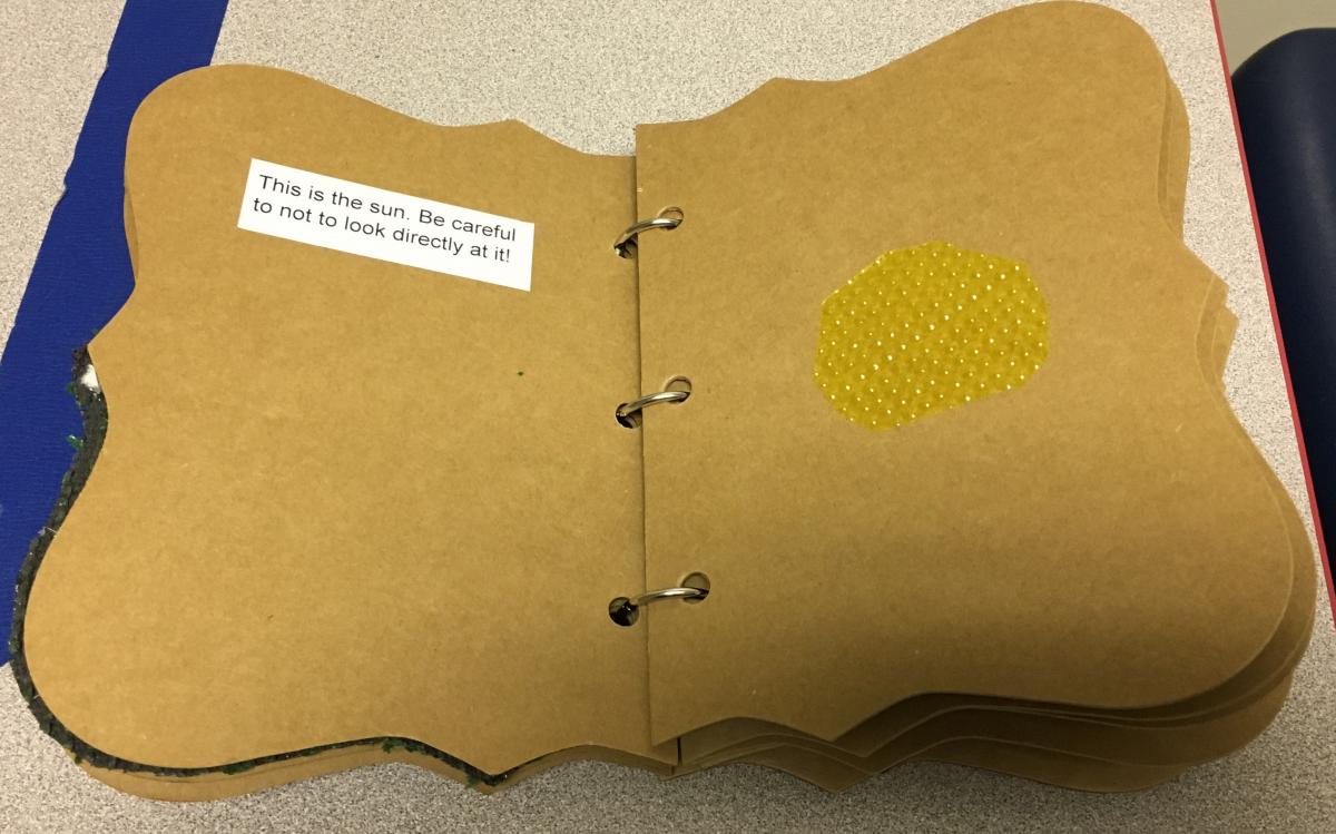 a page with a tactile object representing the sun and text explaining the object