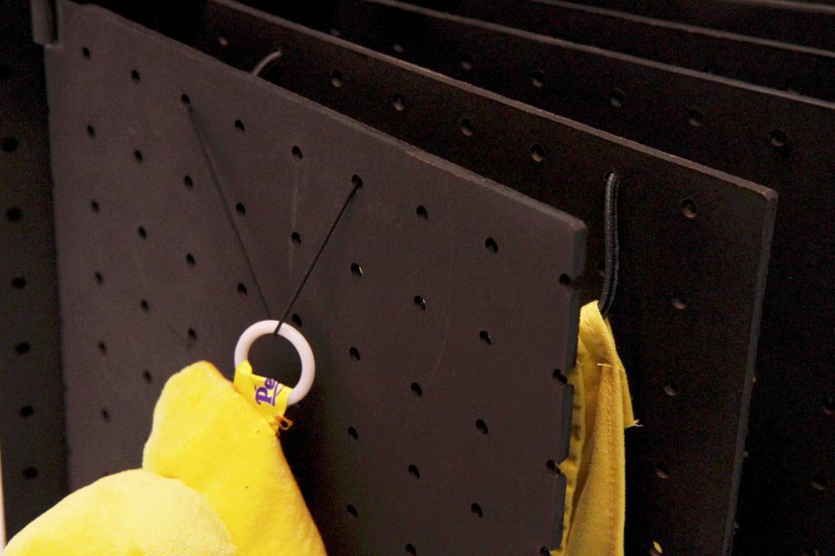 Close-up of elastic and rings holding objects in place on Pegboard book