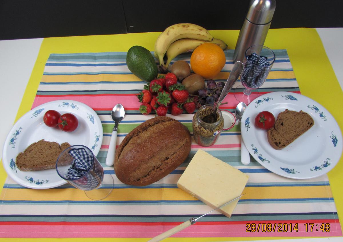 picnic with fruit and plates and a thermos and silverware