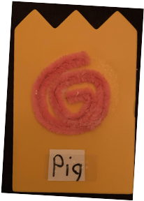 Symbol card with pink pipe cleaner representing a pig's tail