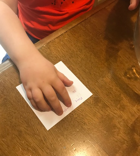 Liam reading the playdough recipe in braille